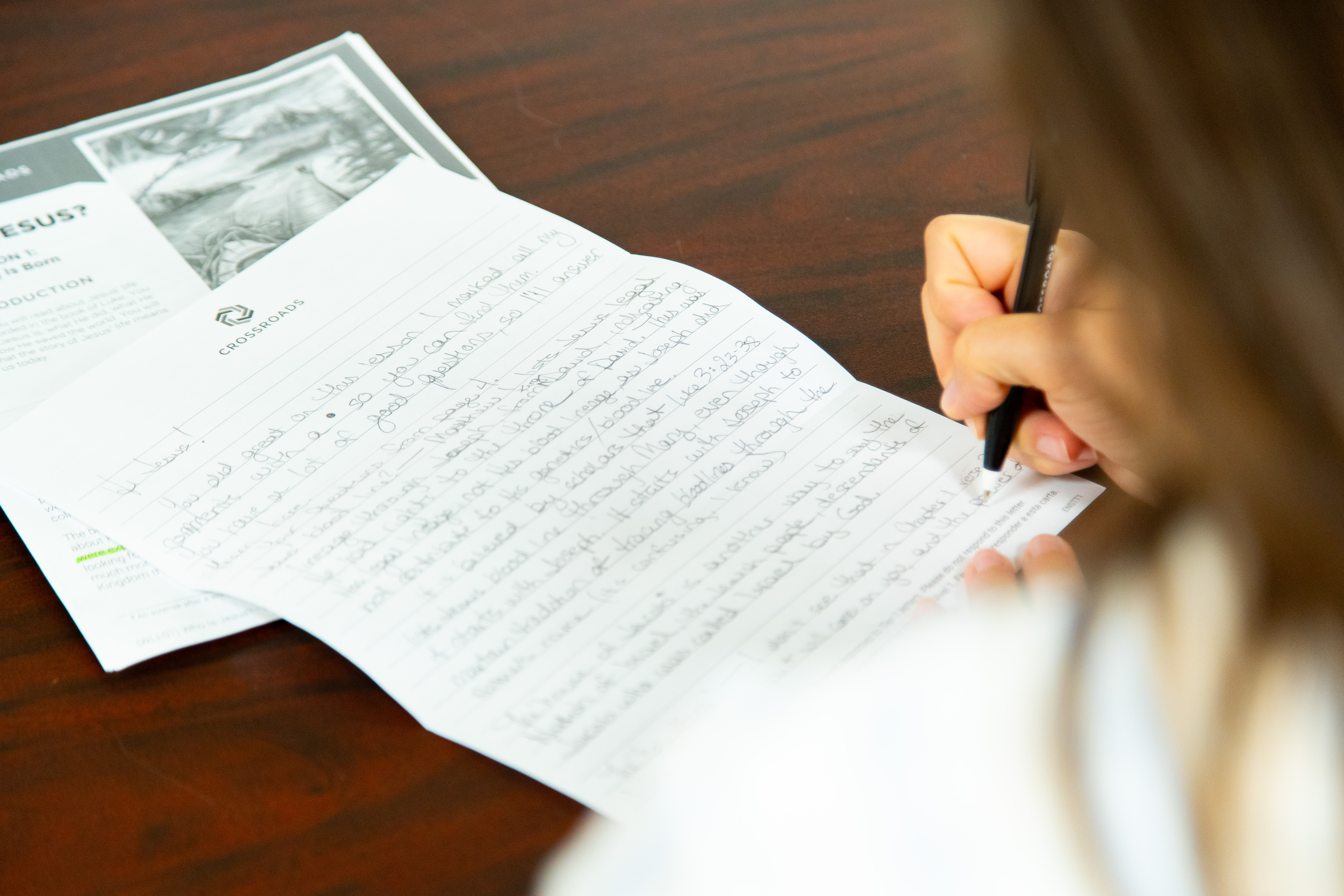 Crossroads mentor writing a letter of encouragement to a student in prison.